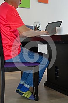 Detail of a person at the dining room table working on his laptop photo