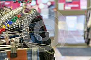 Detail photo - trousers and jeans on hangers in charity thrift shop
