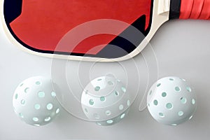 Detail of pickleball balls and red racket and isolated white