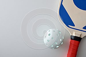 Detail of pickleball racket and ball isolated on white table