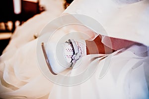 Detail of a pink shoe of a playful girl among her white party dress