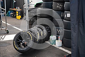 Pirelli PZero slick tire stacks. marked with notes with white chalk and a bottle of water