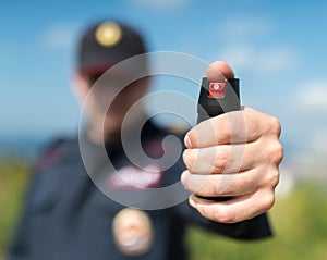 Detail of a police officer holding pepper spray.