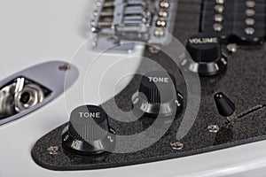 Detail of the potentiometers of a white electric guitar photo