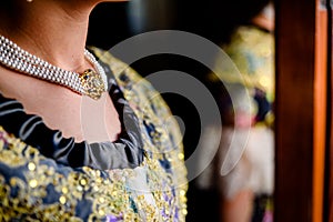 Detail of a pretty woman dressed in the traditional Valencian Fallera dress with her neck decorated with a luxurious necklace photo