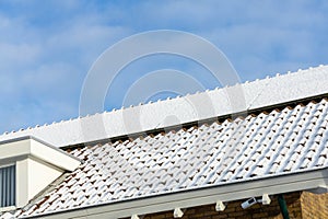 Detail of Private solar panels with snow on a detached bungalow family house on the roof in the winter.