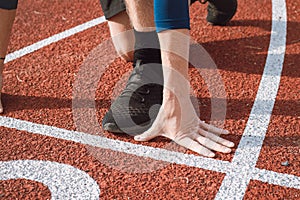 Detail of a professional athlete`s hand position at the start of a 100m sprint. Outdoor athletics oval photo