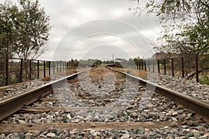 Detail of the rails of the tracks of a train that are lost in the infinity surrounded by boulders. Concept trains, tracks,