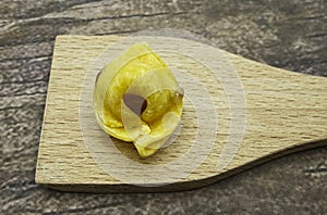 Detail of raw Tortellino, traditional italian pasta. Wooden background. Macro image. photo