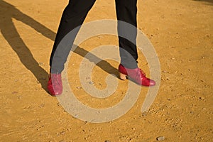 Detail of red colored flamenco dance shoes for men, on an albero floor. Typical Spanish concept, art, dance, culture, tradition