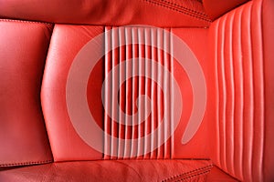 Detail of the red leather seat of a maserati with various folds and details in order to look like a graphic background photo