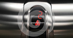 Detail of red led with number two of elevator that go up from second to third floor, business and technology