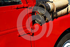 Detail of red vintage firetruck with fire hose