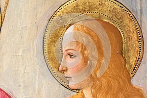 Detail of renaissance fresco showing the blond profile of beautiful female catholic saint
