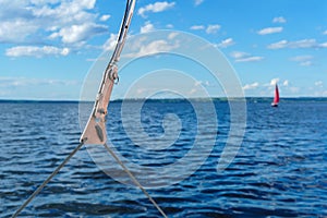 Detail of rigging close-up against the background of a blurred sea landscape with a scarlet sail in the distance