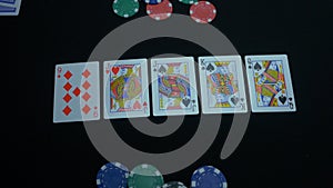 Detail of a royal flush on black background. Royal Flush of spade in poker game on a black background. Player collected