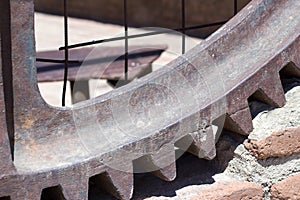 Detail of a rusty gear on brick wall