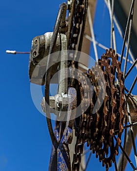 Detail of rusty gear of a mountain bike against the blue sky in the background