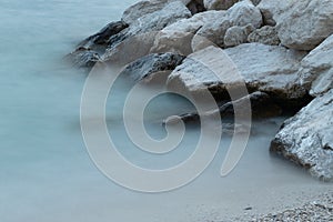 Detail from sea shore, landscape with wet rocks and pebble beach, abstract water