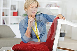 Detail senior woman re-upholstering chair