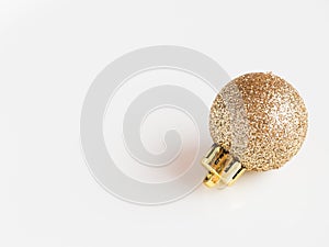 Detail of a shiny and flashy glitter gold christmas ornament on white background