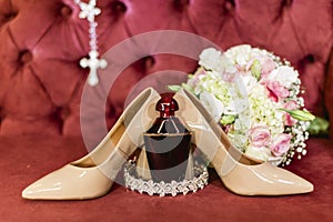 Detail of shoes, perfume and bouquet of the bride