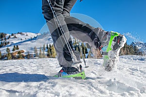 Detail of shoes in the snow with crampons during mountain walk in winter