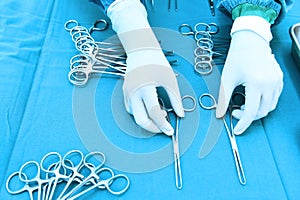 Detail shot of steralized surgery instruments with a hand grabbing a tool