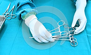 Detail shot of steralized surgery instruments with a hand grabbing a tool