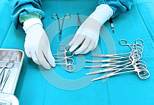 Detail shot of steralized surgery instruments with a hand grabbing a tool