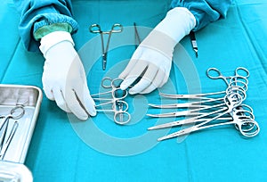 Detail shot of steralized surgery instruments with a hand grabbing a tool photo