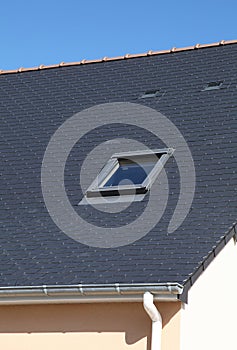 Detail of a slate roof of a house with a skylight