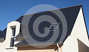 Detail of a slate roof of a house with a skylight