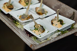 Detail of a small plate of mussel with allioli and parsley in a catering. Concept food, wedding, menu, catering photo