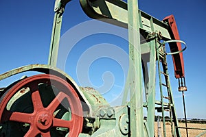 Detail of small scale crude oil pump udner sky
