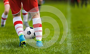 Detail Soccer Background. Close up legs and feet of football player in white socks and blue cleats playing game on green grass