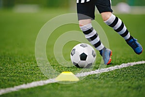 Detail soccer player kicking ball on pitch sideline. Soccer player on a game photo