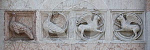 Detail of some marble medieval bas relief outside the Baptistery in Parma