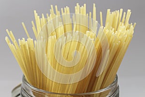 Detail of Spaghetti in a glass jar on gray background