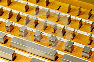 Detail of stainless steel rectangular gauge block metric etalons placed in wooden case