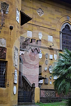 Detail, with staircase and many coats of arms in stone, of the wall overlooking the park, of the villa Stibbert in Florence.