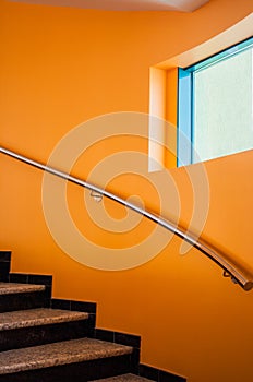 Curved staircase in a luxury office building next to an orange w