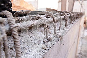 Detail of steel bars inside cement for the reinforced concrete of the foundations of a wall of a building under construction, with