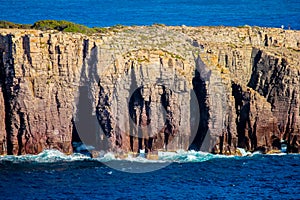 Detail of stratified cliff with breaking waves