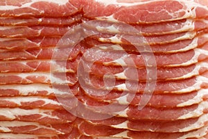 Detail of strips of streaky uncooked bacon.