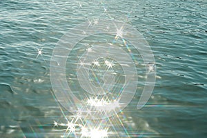 Detail of a sunlight reflecting in glittering sea. sparkler in water - background. sea water with sun glare and ripple. Powerful a