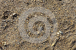 Detail of surface texture with small pebble rock on dirty ground