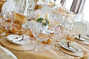 Detail of a table set in ocher color organza for a wedding banquet