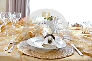 Detail of a table set in ocher color organza for a wedding banquet