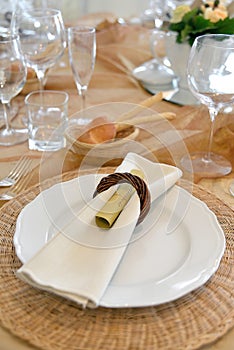 Detail of a table set in ocher color organza for a wedding banquet